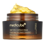 Open jar of Medicube Deep Vita C Capsule Cream showing yellow vitamin C capsules in transparent gel texture