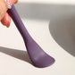 Close-up of the flat applicator side of a purple dual-ended silicone skincare tool